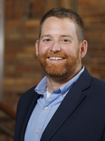 Photo of Adam Fouche in a suit